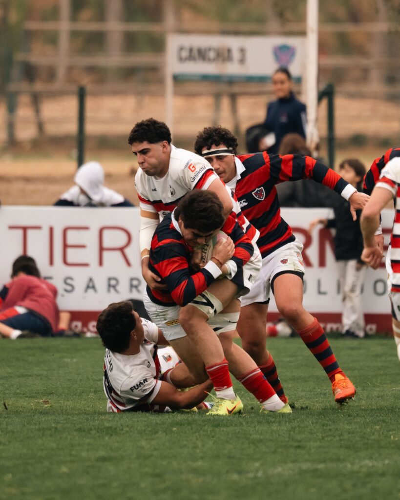 Intense rugby action showcasing players in motion on a grassy field during a competitive match.